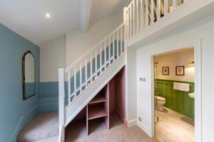 a bathroom with a staircase and a toilet in a house at Escape Boutique B&B in Llandudno