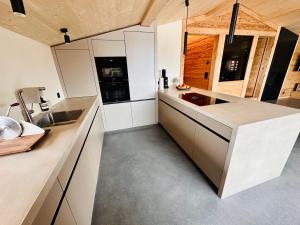 a kitchen with white cabinets and a sink at Casa Felice in Trin