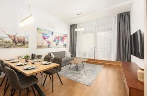 a living room with a table and chairs and a couch at Appartement Tamino - City Appartement by Schladmingurlaub in Schladming