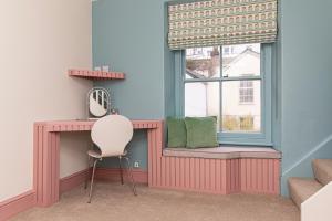 a window seat with a chair in a room at Escape Boutique B&B in Llandudno