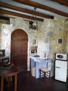cocina con pared de piedra, fregadero y fogones en Studio Tsiliviani, en Loukádhika