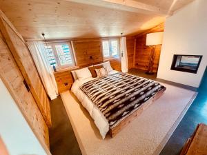 a bedroom with a large bed in a room with wooden walls at Casa Felice in Trin