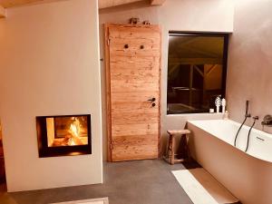a bathroom with a fireplace and a bath tub and a fire place at Casa Felice in Trin