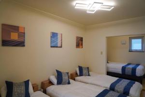 a room with two beds and a mirror at Nesaki Native in Hakodate