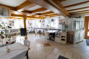 a restaurant with tables and chairs in a room at Hotel Landgasthaus Rössle in Hofweier