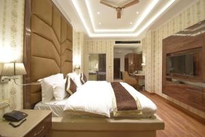 a bedroom with a large bed and a television at Grand Him Queen AC Centralized in Dharamshala