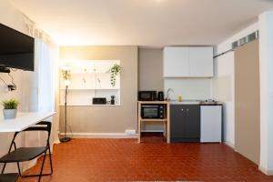 a kitchen with a refrigerator and a table and chairs at Magnifique studio cosy et calme in Digne-les-Bains