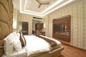 a bedroom with a large bed and a television at Grand Him Queen AC Centralized in Dharamshala