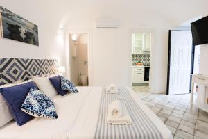a bedroom with a large bed with blue and white pillows at MAISON SAINT MICHAEL in Capri