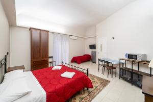 una camera da letto con un letto rosso e un soggiorno di BELLINIKATANESUITE a Catania
