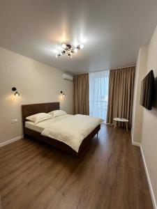ein Schlafzimmer mit einem großen Bett und einem großen Fenster in der Unterkunft Апартаменти м.Буча ЖК Гранд Бурже in Bucha