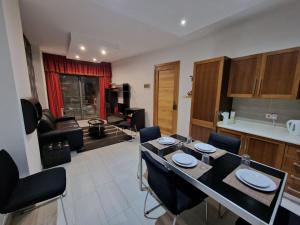 uma cozinha e sala de estar com mesa e cadeiras em MIVE -Bugibba Modern Apartment next to main square em St. Paul's Bay