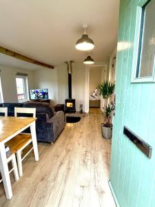 - un salon avec une table et un canapé dans l'établissement old cricket pavilion, Riding mill, Northumberland, à Newcastle upon Tyne