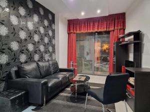 uma sala de estar com um sofá de couro e uma mesa em MIVE -Bugibba Modern Apartment next to main square em St. Paul's Bay