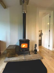 a fireplace in a living room with a stove at old cricket pavilion, Riding mill, Northumberland in Newcastle upon Tyne