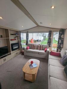 a living room with couches and a coffee table at Hidden Gem Wilksworth Caravan Park Rural and Peaceful Setting in Wimborne Minster