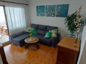 a living room with a blue couch and a table at Sol Marina Apartment in Salou