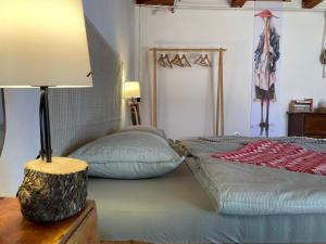 a bedroom with a bed with a lamp on a table at Chez Sári in Sarud