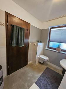 a bathroom with a toilet and a sink and a window at d' Aussicht nach LA in Deggendorf +13 photos