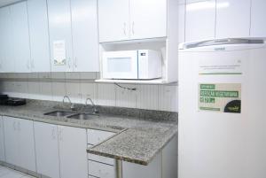 贝洛奥里藏特Br Hostel的带水槽和微波炉的白色厨房