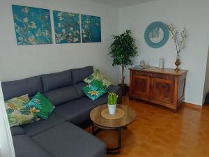 a living room with a blue couch and a table at Sol Marina Apartment in Salou