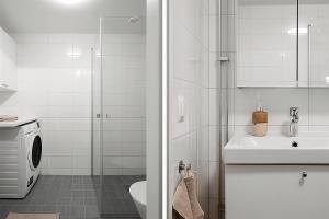 a white bathroom with a sink and a toilet at Beautiful Central Apartment in Stockholm