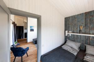 Un dormitorio con una cama, una silla y un espejo. en Ganu Māja, en Užava