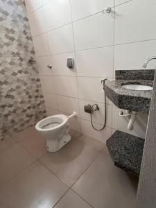 a bathroom with a toilet and a sink at Apartamento Loft in Rio Verde