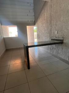 una mesa negra en una habitación con una pared de piedra en Apartamento Loft, en Rio Verde
