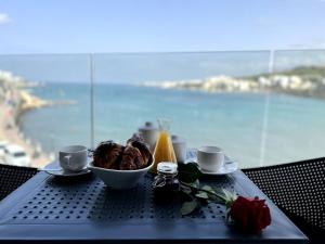 un tavolo con una ciotola di cibo e due tazze di Dearborn Seafront a San Pawl il-Baħar