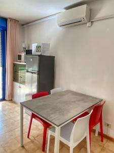 cocina con mesa, sillas y nevera en Grazioso Appartamento n 40 a Bibione a 100mt dal mare, en Bibione