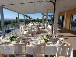 a dining room with white tables and white chairs at Agriturismo Le Arcate in Sinio