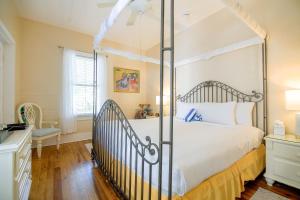 a bedroom with a white bed with a metal canopy at Ambrosia Key West in Key West