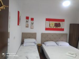 2 Betten in einem Zimmer mit weißen Wänden in der Unterkunft Pousada irmãos Oliveira in Lindóia