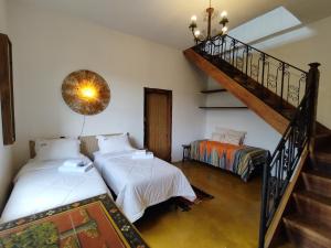 1 dormitorio con 2 camas y escalera en Casa Moitará en Tiradentes