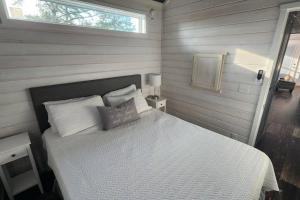 um quarto com uma cama com lençóis brancos e uma janela em Wheeler Lake Meadow Cabin 4 em Shelby