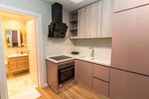 a small kitchen with a sink and a stove at Blissful Apartments in Sarandë +70 photos