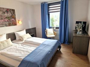 a hotel room with two beds and a window at Hotel Engelskirchen in Engelskirchen