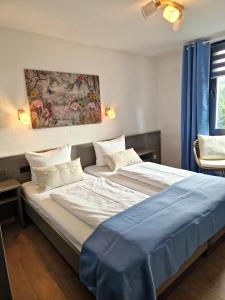 two beds in a room with blue curtains at Hotel Engelskirchen in Engelskirchen