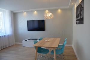 a dining room with a table and blue chairs at Apartament na Starówce Grobla I in Gdańsk