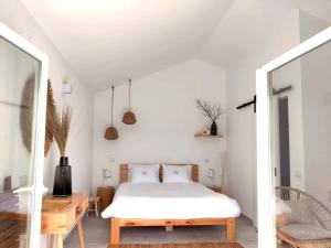 a bedroom with a white bed and a wooden table at Quinta do Alento in Sesimbra