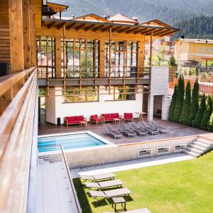 a house with a swimming pool and a patio at Corona Dolomites Hotel in Andalo