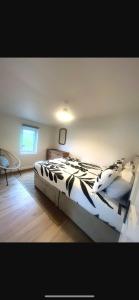 um quarto com uma cama com um edredão preto e branco em old cricket pavilion, Riding mill, Northumberland em Newcastle upon Tyne