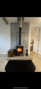 a fireplace in a living room with a rug at old cricket pavilion, Riding mill, Northumberland in Newcastle upon Tyne