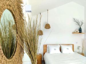 1 dormitorio con 1 cama, espejo y plantas en Quinta do Alento, en Sesimbra