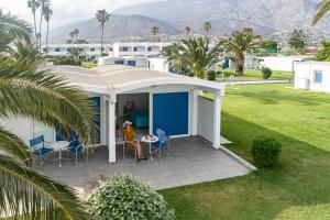 une maison avec une terrasse couverte dotée d'une table et de chaises dans l'établissement Kinetta Beach Resort and Spa, à Kinetta