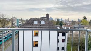 a white building with a roof with a city in the background at Living in a penthouse in Frankfurt, with balcony for smokers in Frankfurt/Main