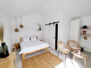a bedroom with a bed and two chairs at Quinta do Alento in Sesimbra