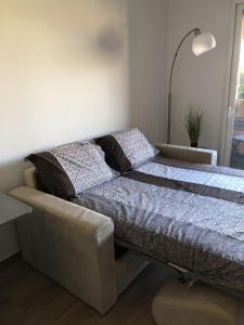 ein Bett und ein Sofa in einem Zimmer in der Unterkunft SAM SUFFY in Saint-Cyr-sur-Mer