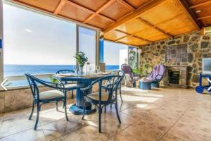a dining room with a table and chairs and a fireplace at Penthouse Urbanizacion Montemarina Anfi del Mar in Mogán +29 photos